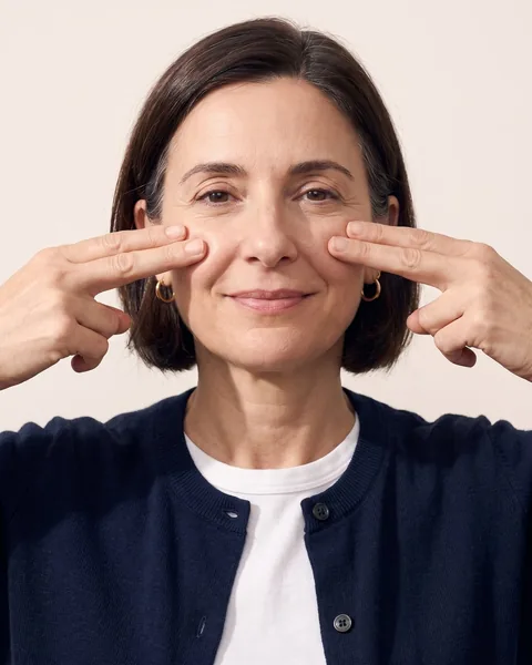 Fingertips pressing on both cheekbones