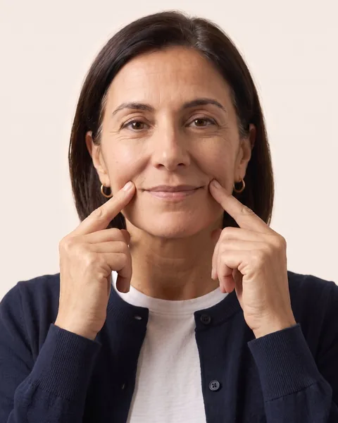 Fingertips at both corners of the mouth