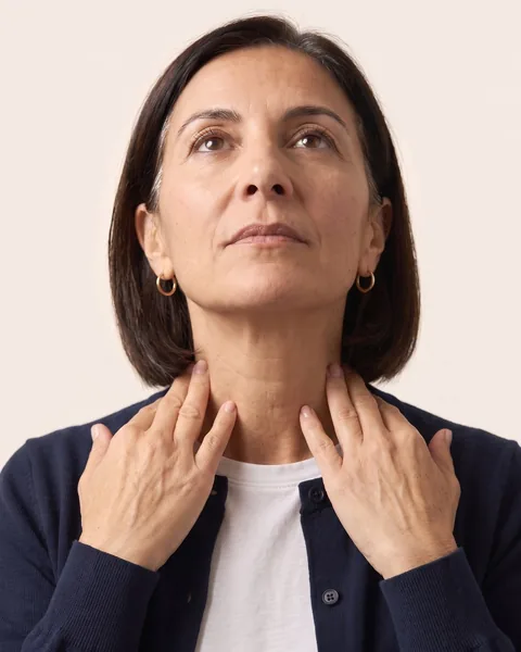 Both hands pressed flat just below the collarbones
